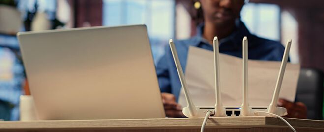 Roteador Wi-Fi ao lado de notebook em ambiente residencial
